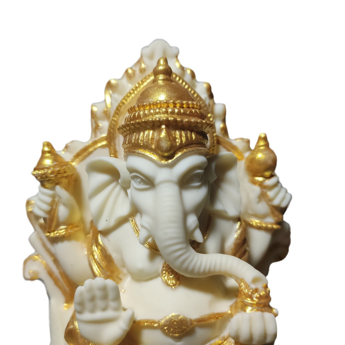 Close-up of gold-accent ivory nut Ganesha statue showing crown, face and sculpted hand details
