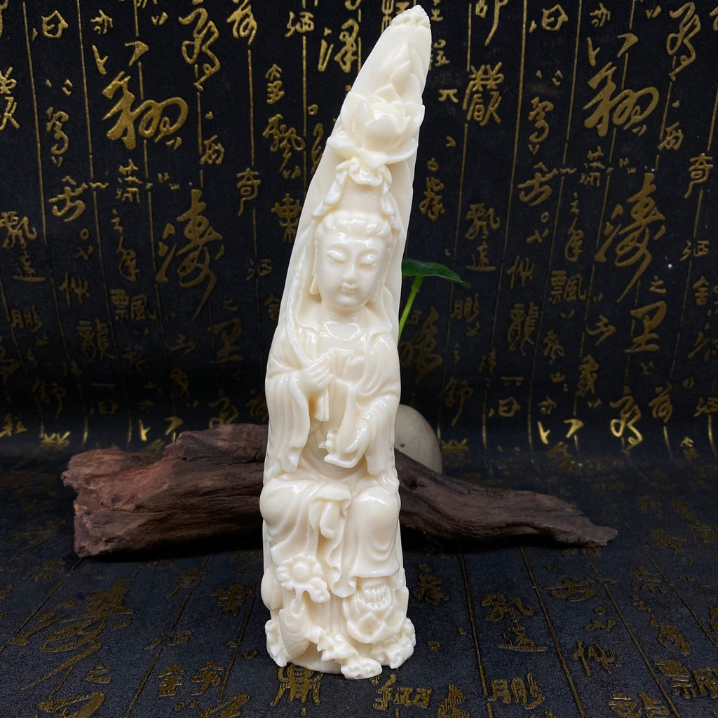 Tall ivory nut Guanyin figurine with elongated crescent-like sculptural form and lotus-cloud base
