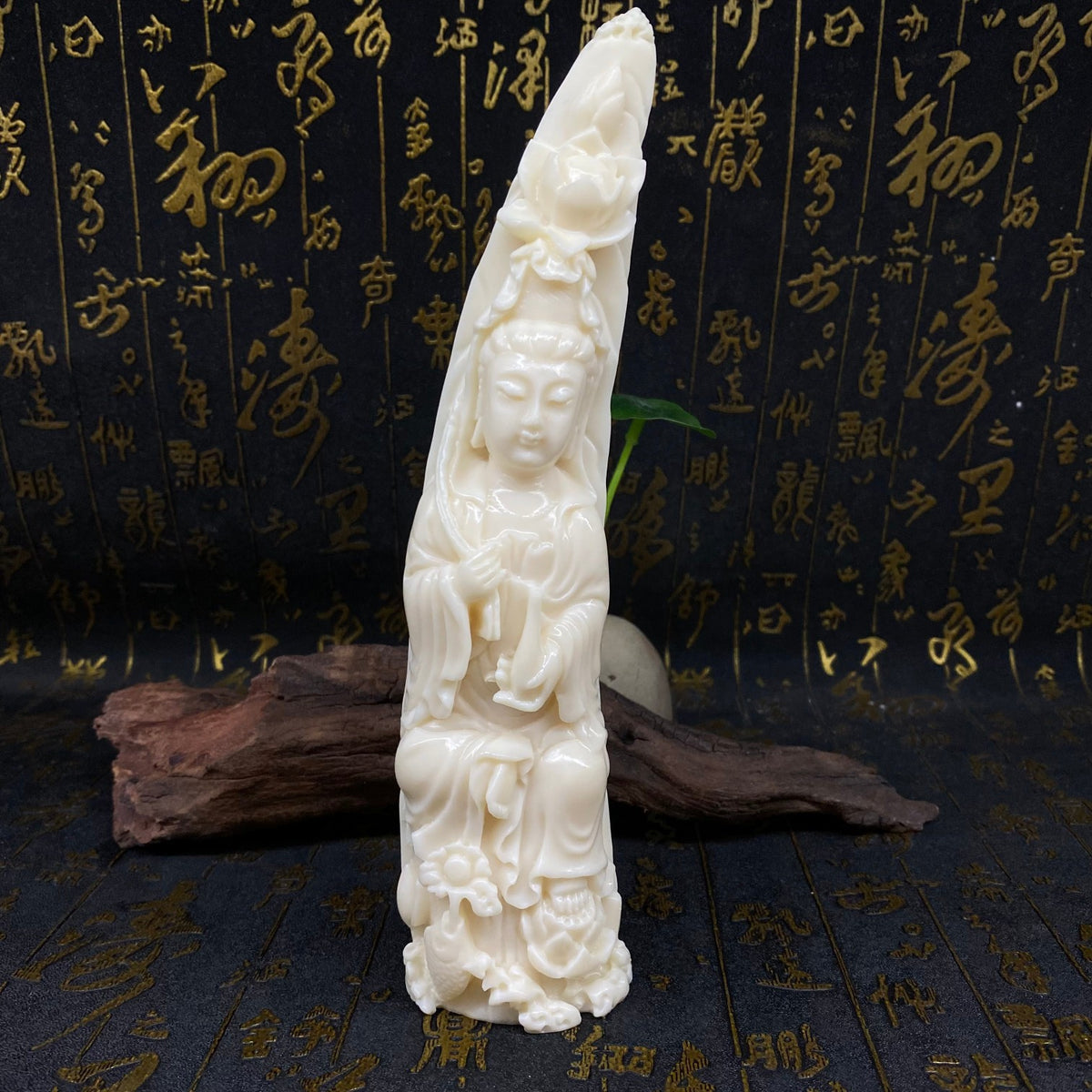 Tall ivory nut Guanyin figurine with elongated crescent-like sculptural form and lotus-cloud base