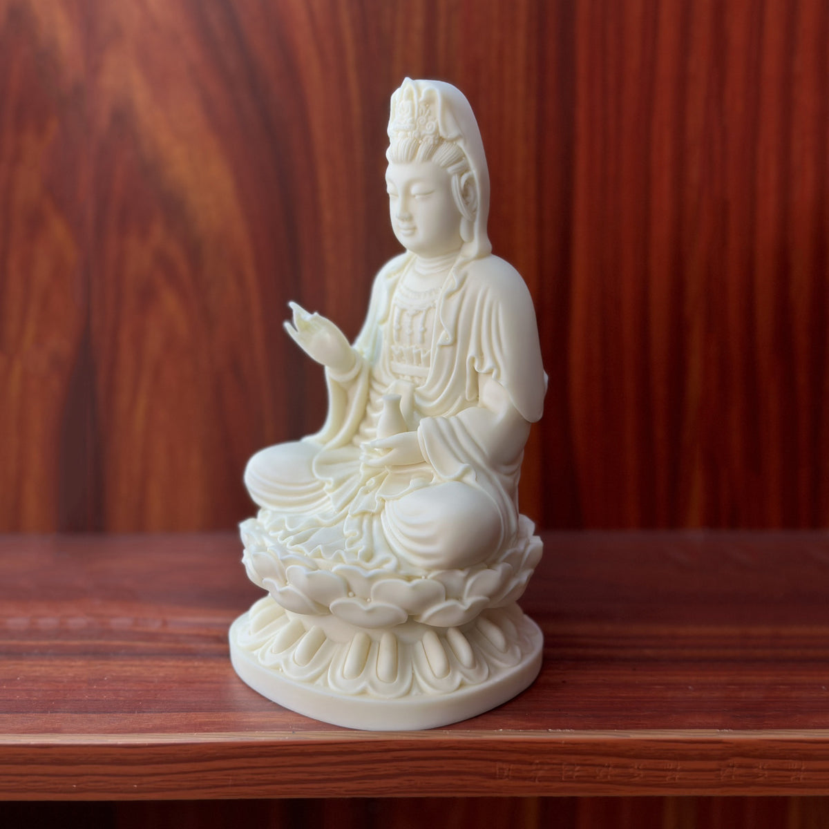 Side view of ivory nut Jingping Guanyin statue showing lotus throne and robe detail