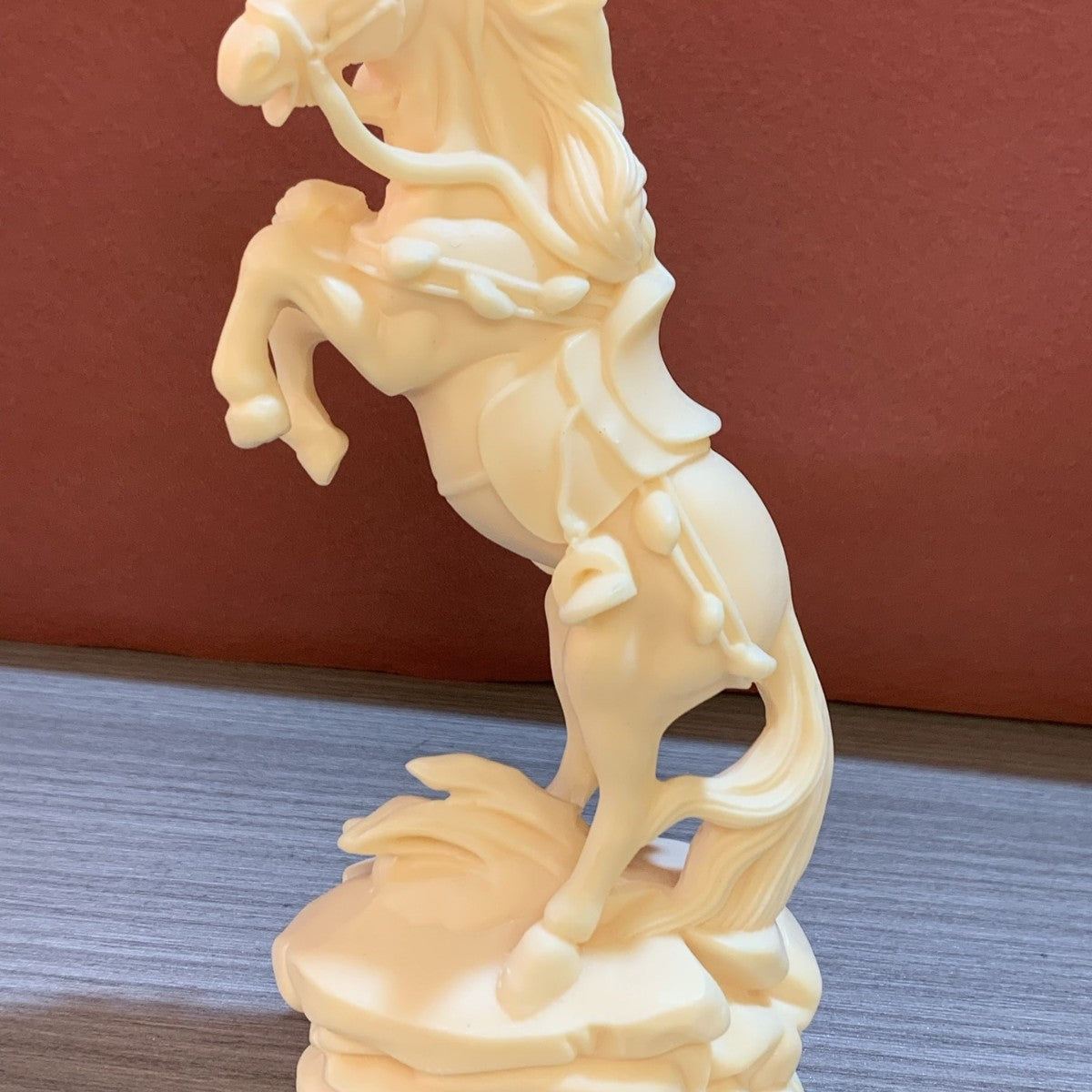Close-up of ivory nut rearing horse figurine with money charm and flowing mane