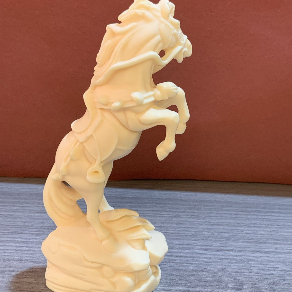 Ivory nut rearing horse decorative statue shown from a three-quarter angle with money motif