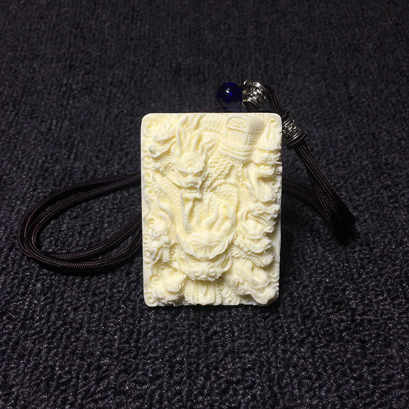 Hand-carved ivory nut multi-dragon fortune motif pendant with dark cord