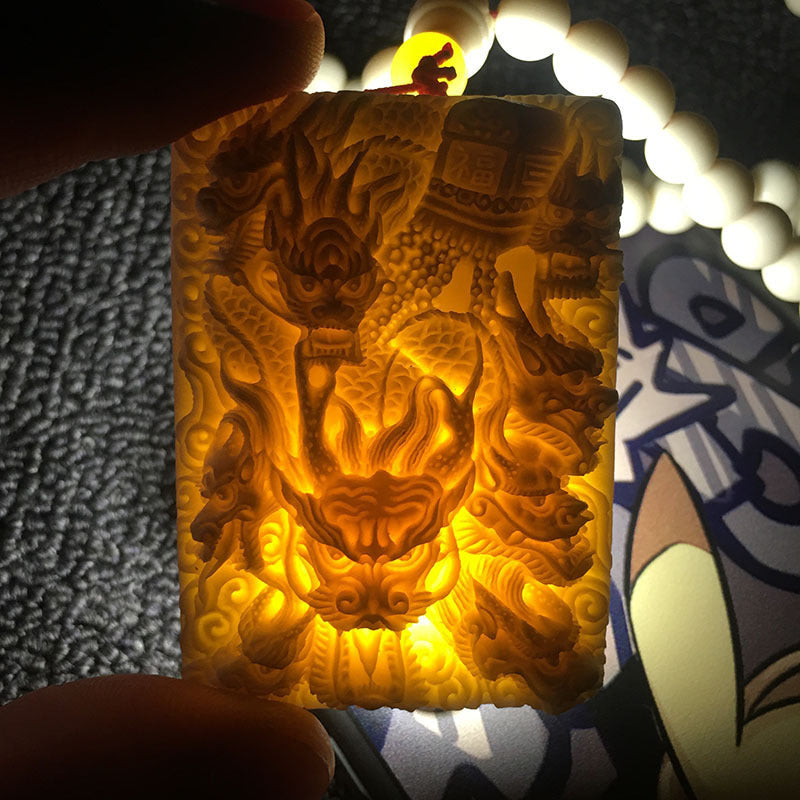 Backlit ivory nut dragon relief showing natural translucency and deep carving
