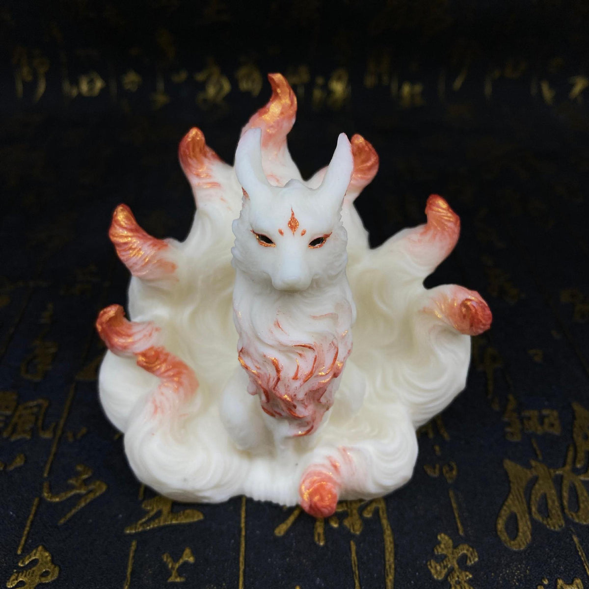 Ivory nut nine-tail fox figurine with rose-gold accent details shown from a front angle