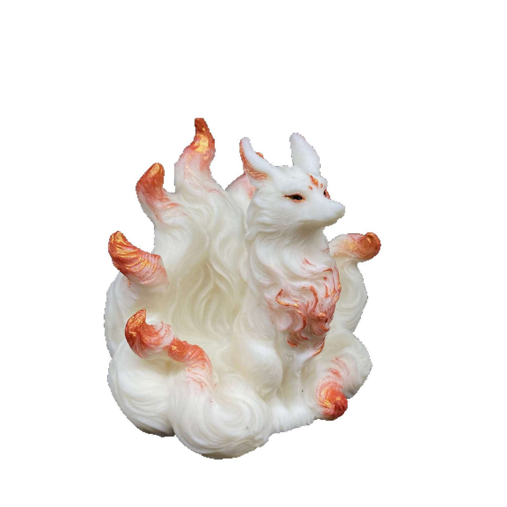 Ivory nut nine-tail fox figurine with rose-gold accents isolated on white background