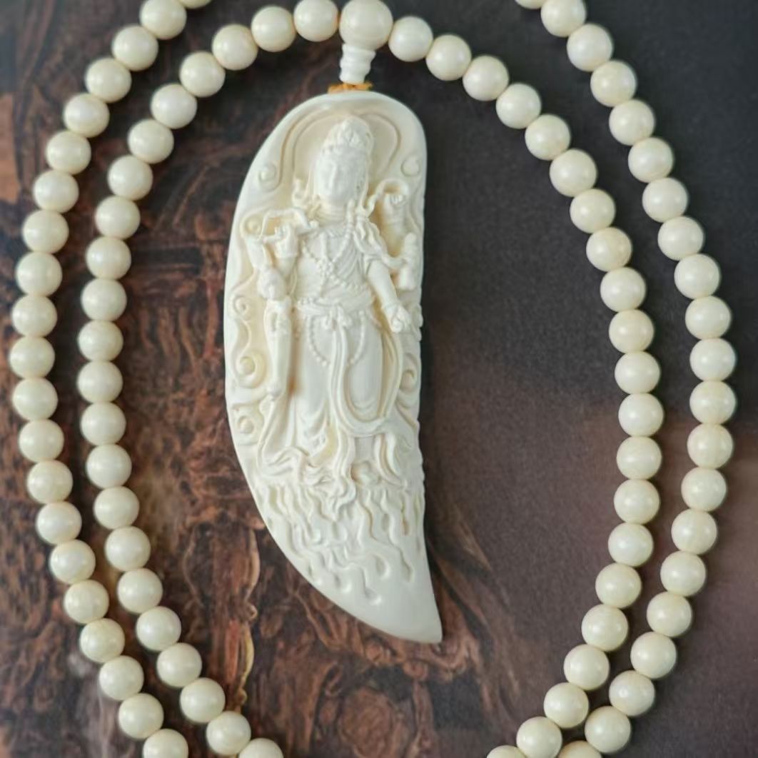 Ivory nut Samantabhadra crescent pendant with bead strand and carved bodhisattva relief