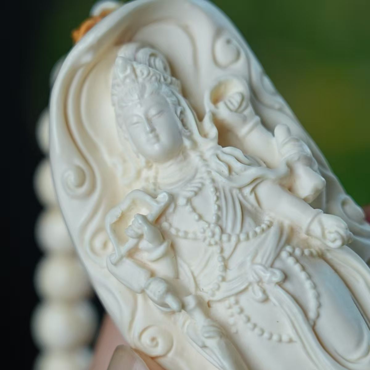 Close-up of ivory nut Samantabhadra bodhisattva relief carving with attendant elephant detail