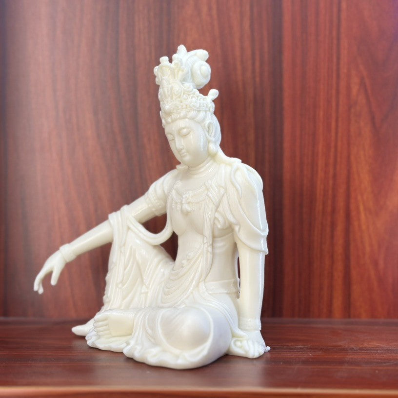 Ivory nut Guanyin statue with relaxed seated posture and flowing robe detail
