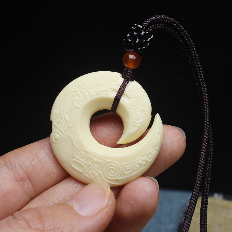 Ivory nut carved spiral pendant product view with dark braided hanging cord