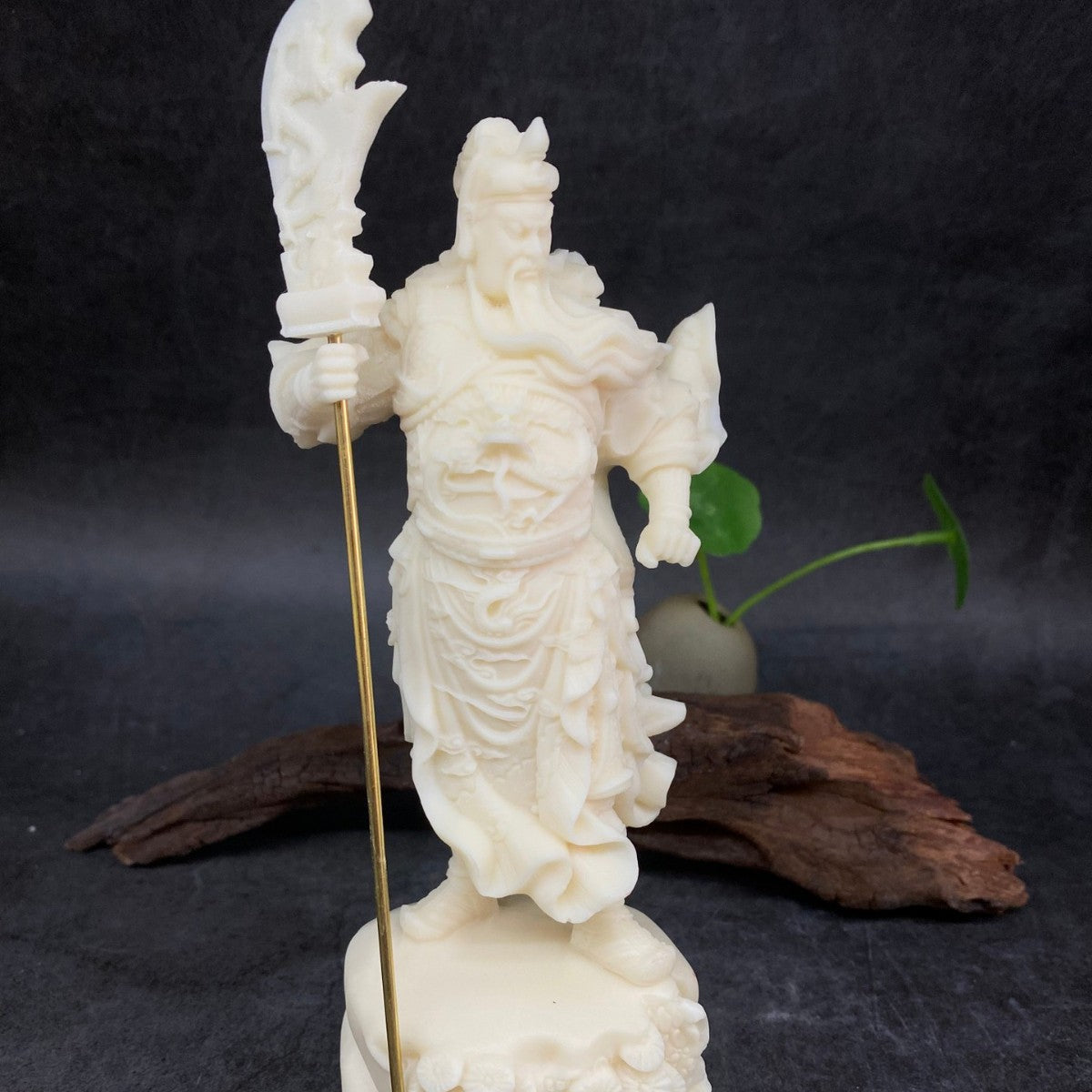 Side view of ivory nut Guan Yu warrior figurine with flowing robes and long guandao weapon