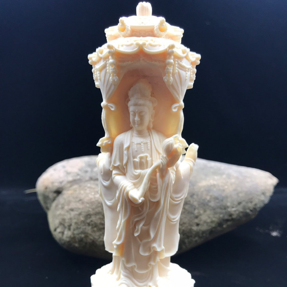 Ivory nut Western Pure Land Three Saints carving shown against stone backdrop