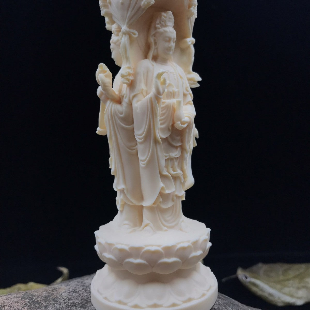 Close detail of ivory nut Buddhist triad ornament with lotus pedestal and flowing robes