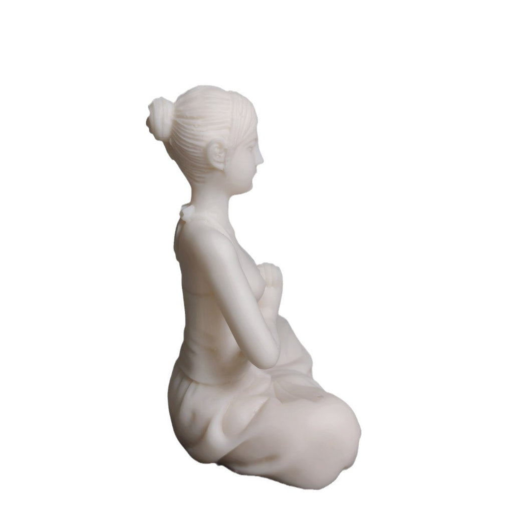Side profile of ivory nut yoga woman figurine in seated namaste meditation pose