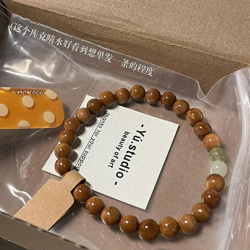 Kuk Bodhi 8mm bracelet with brown beads and white and green decorative accents