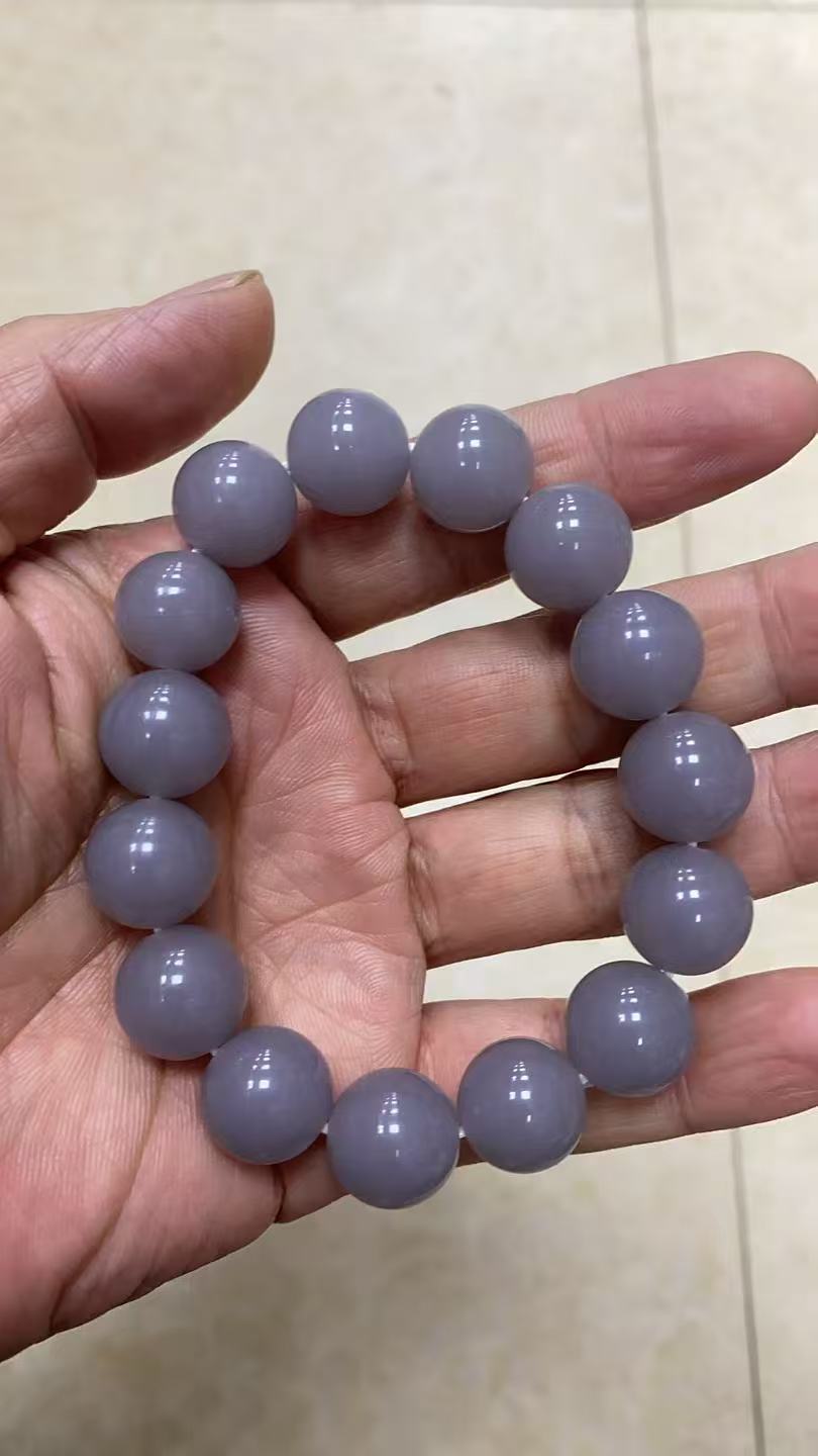 Lavender grey polished round stone bead bracelet in hand