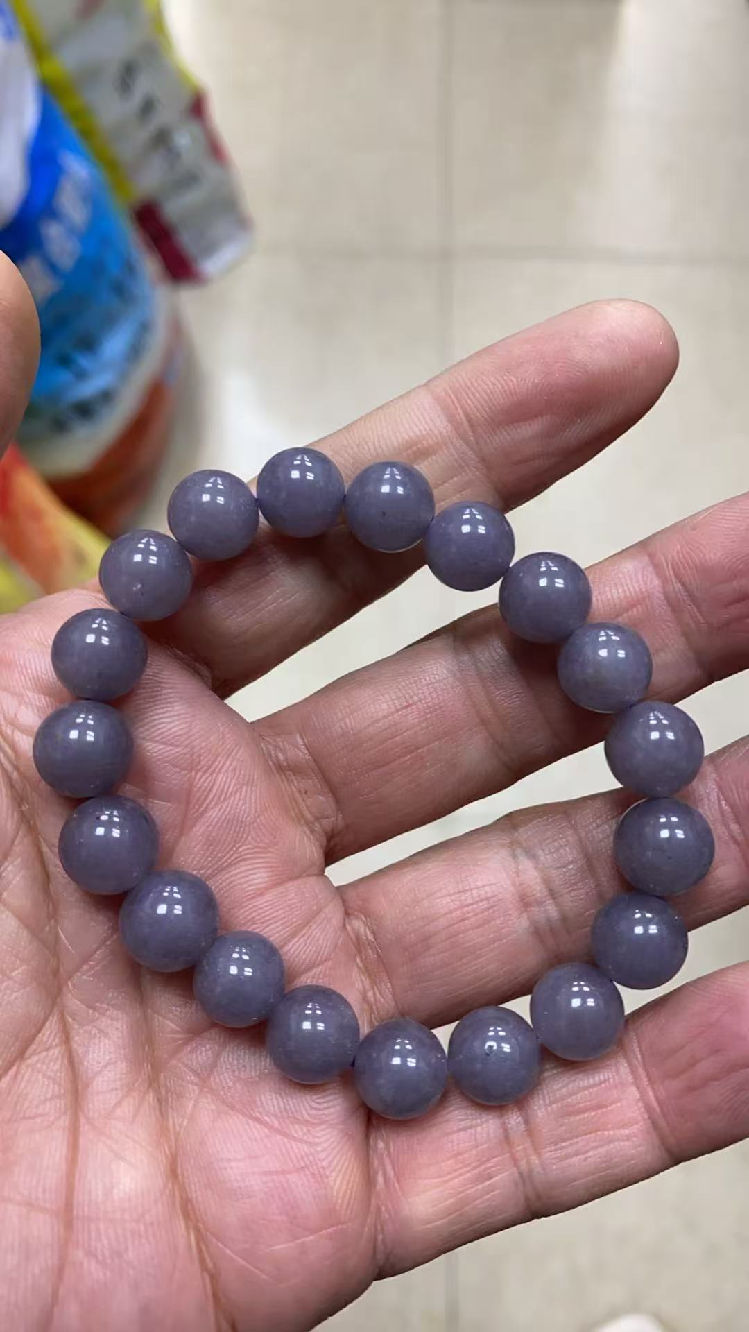 Lavender grey bracelet displayed in hand for scale