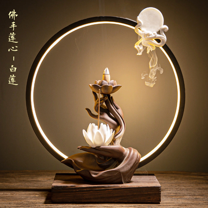 White lotus LED ring incense display with sculptural Buddha hand