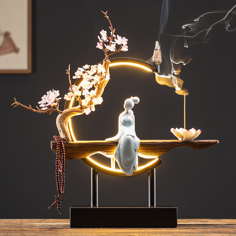 Porcelain-style lady figure in illuminated New Chinese incense display
