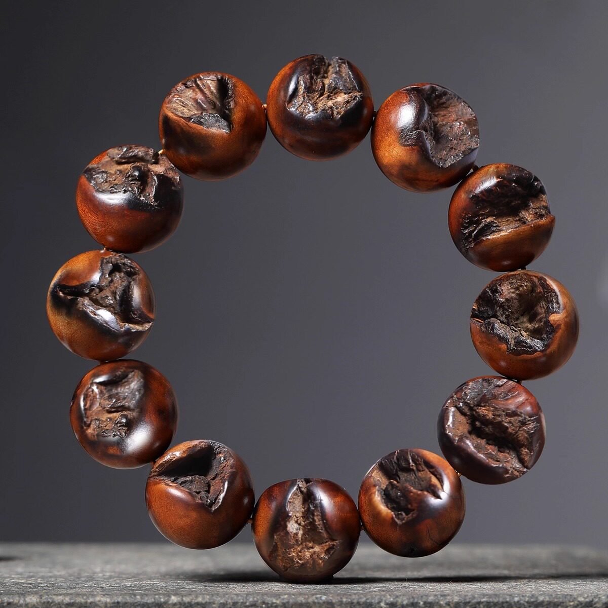 Dark display view of supplier-described Lei Ji Zao wood bracelet showing irregular lightning-scar-style bead surfaces