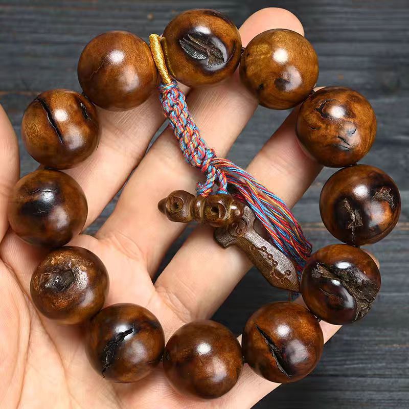 Lei Ji Zao wood bracelet with polished round beads showing natural scar-like dark grain and carved pendant