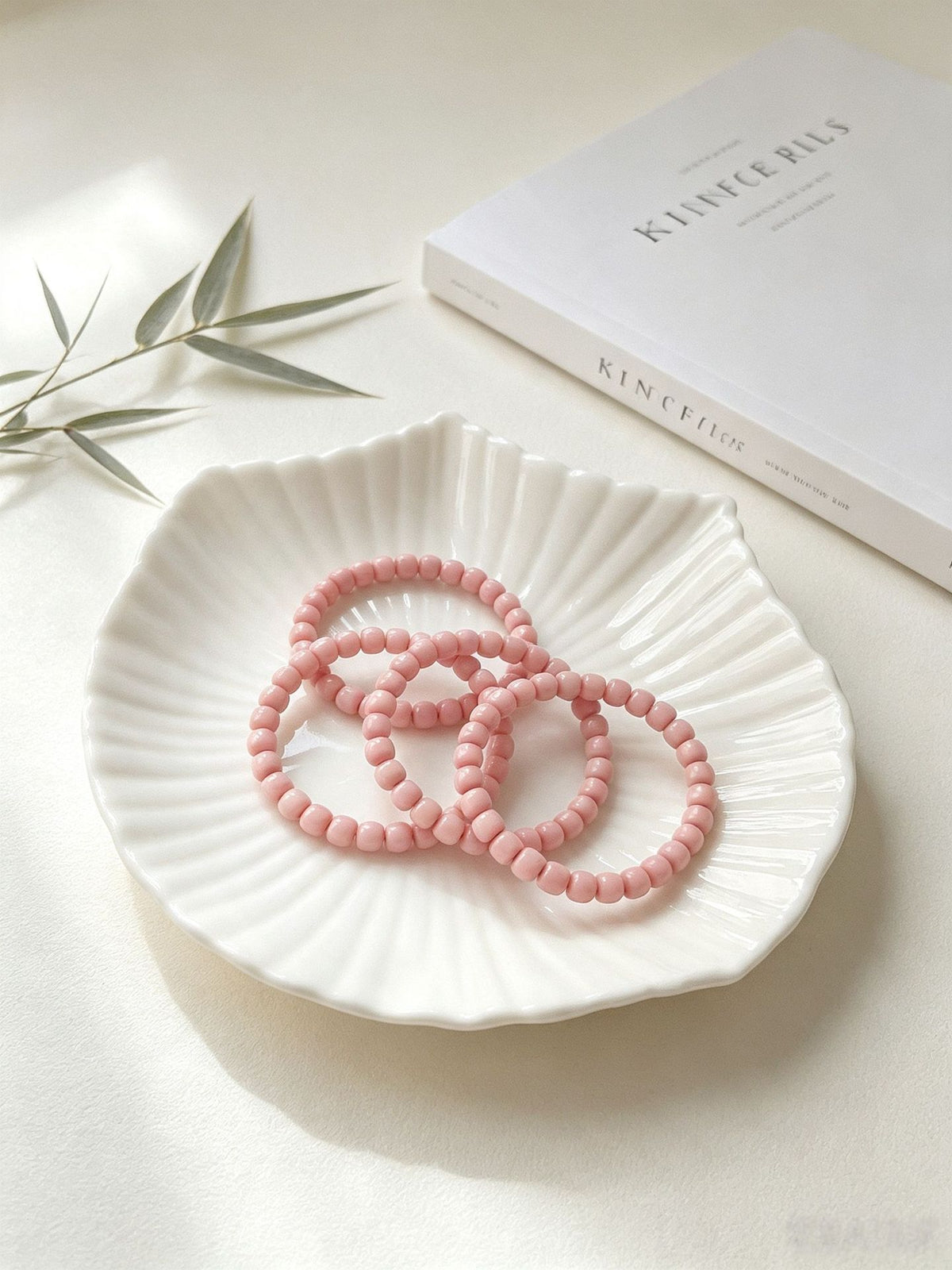 Pink Longji Bodhi old-style barrel bead bracelets displayed on a white ceramic plate