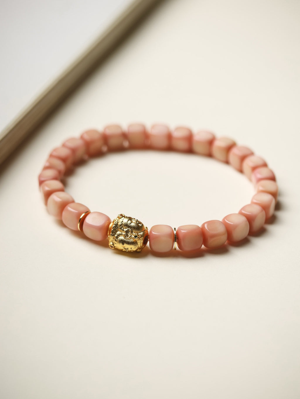 Pink Longji Bodhi candy-cube bracelet with gold-tone three-face Buddha-style accent