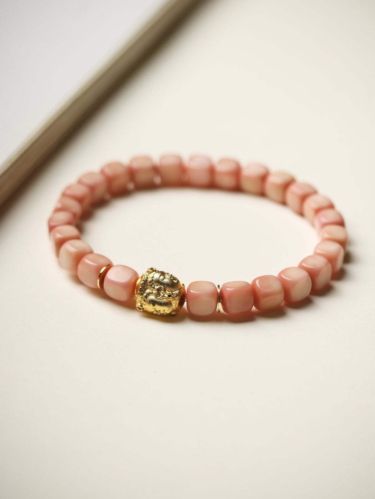 Pink Longji Bodhi candy-cube bracelet with gold-tone three-face Buddha-style accent