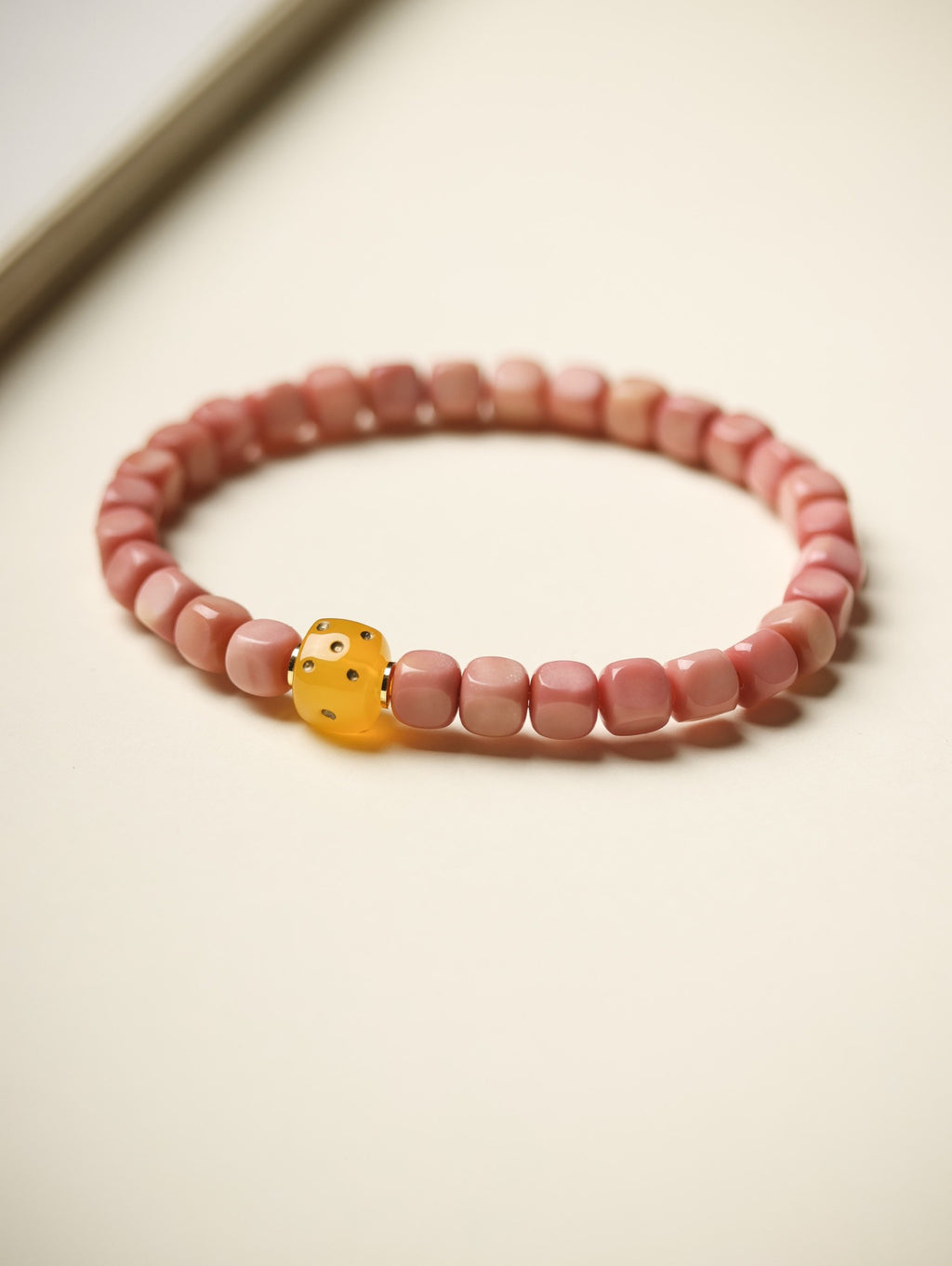 Pink Longji Bodhi candy-cube bracelet with yellow dice-style focal bead