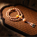 Pink Longji Bodhi hand mala with warm yellow focal beads and New Chinese tassel styling