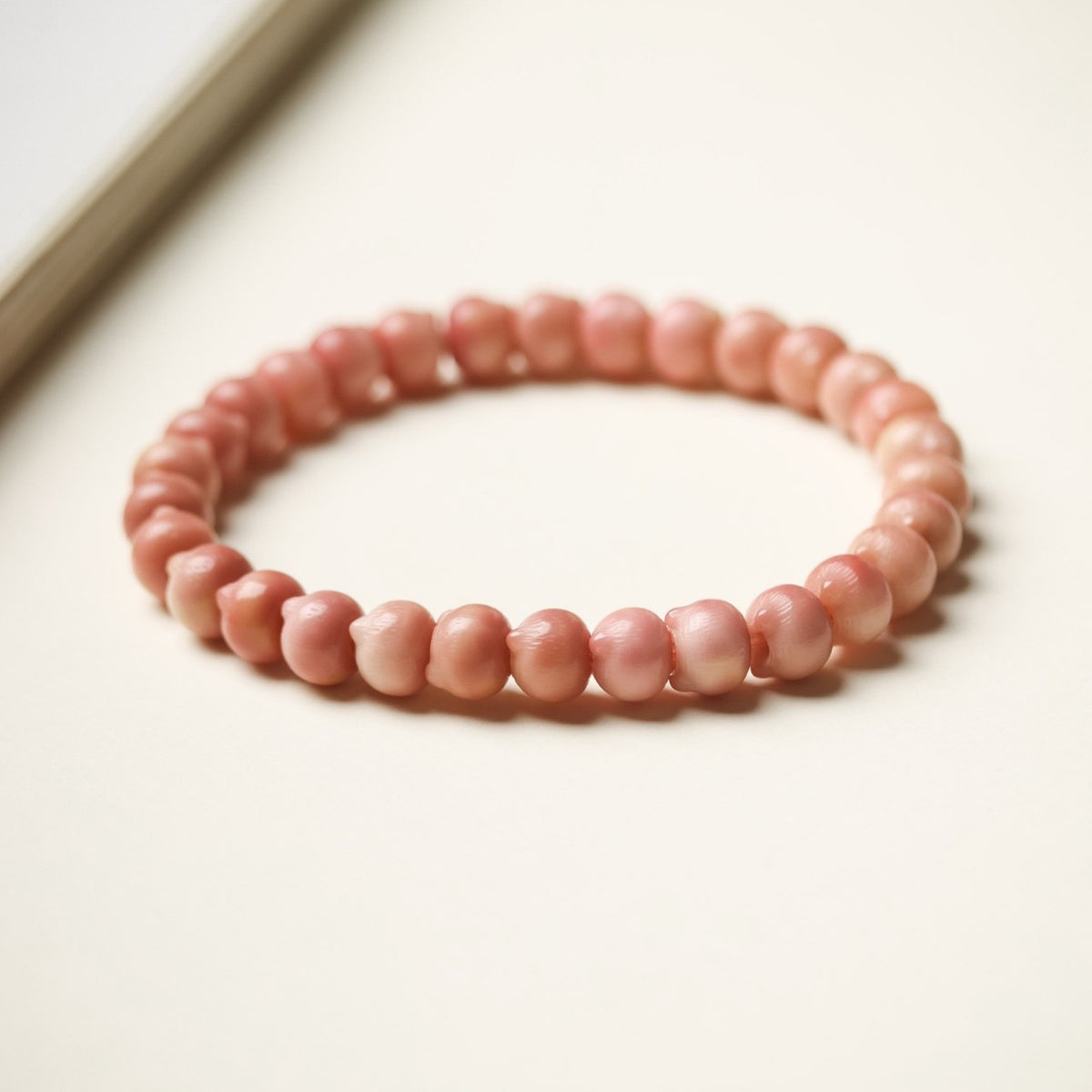 Pink Longji Bodhi small cat-head shaped bead bracelet in soft natural light