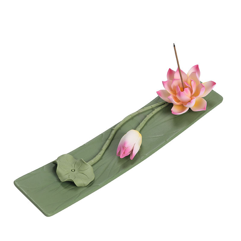 Green lotus leaf ceramic incense stick holder with pink lotus and bud on white background