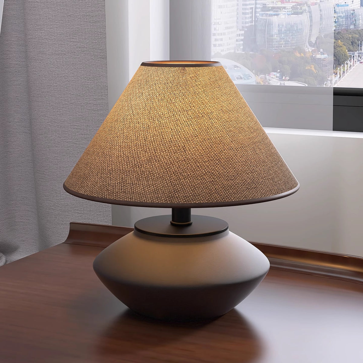 Low Japanese-inspired ceramic table lamp with warm linen shade by window