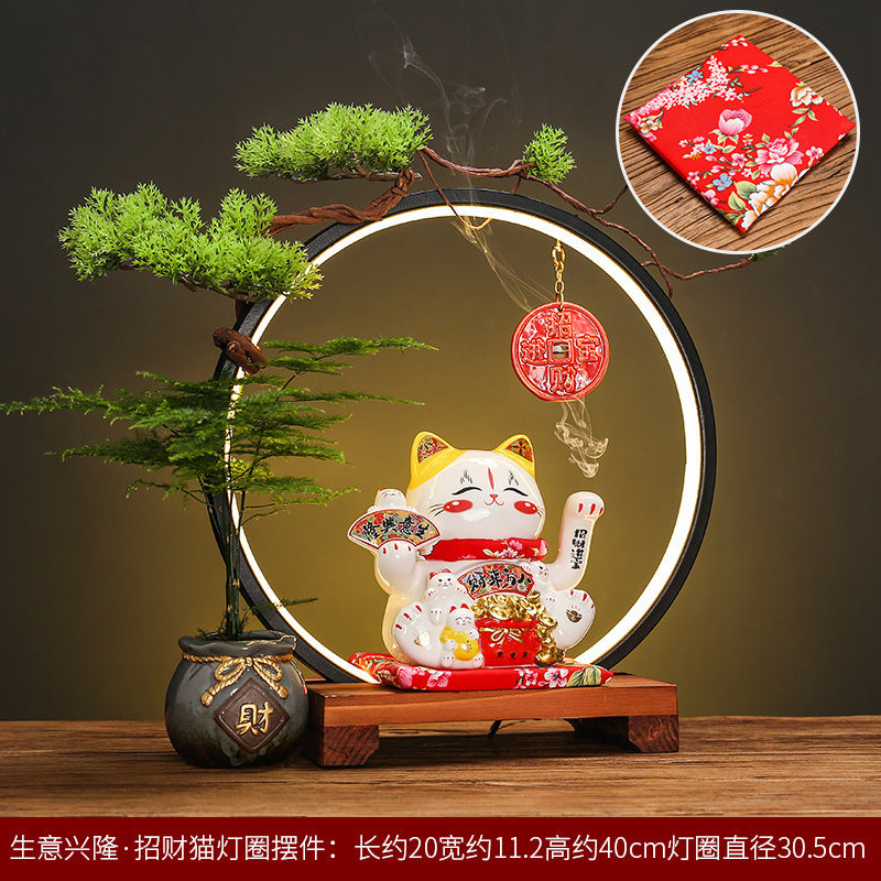 Illuminated lucky cat prosperity display with red coin charm and bonsai ring