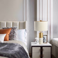 White marble and brass table lamp with fabric drum shade in modern bedroom
