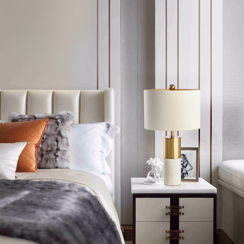 White marble and brass table lamp with fabric drum shade in modern bedroom