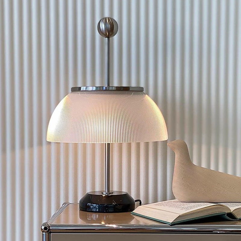 Matte silver ribbed glass table lamp styled beside an open book