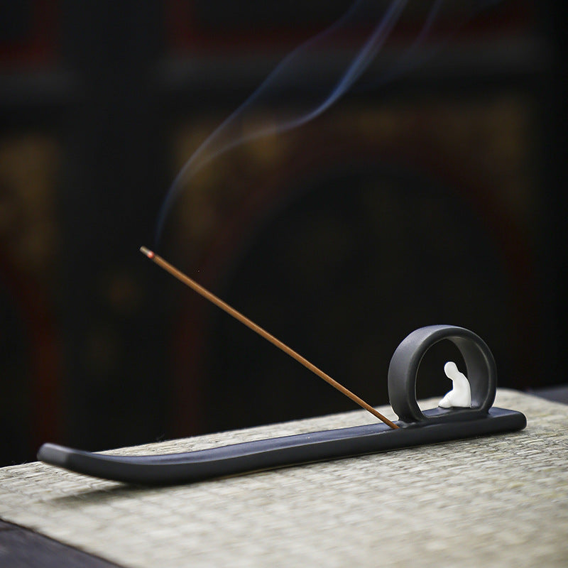 Minimalist matte black Buddha incense stick holder with long ash catcher and rising smoke