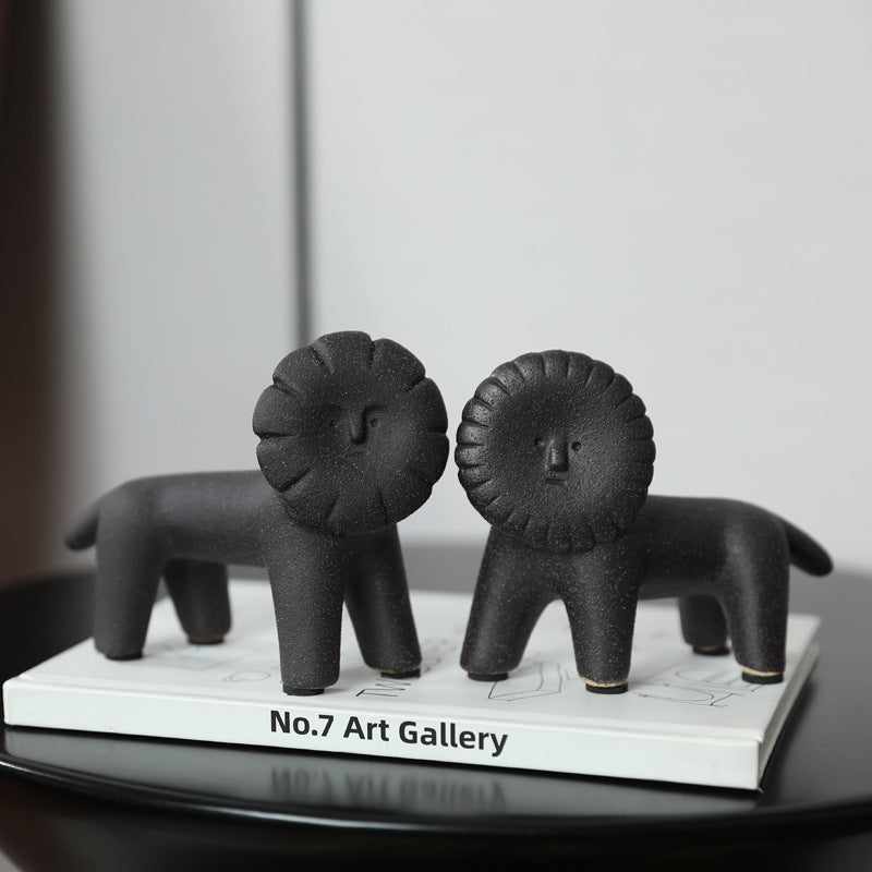 Matte black ceramic lion figurines styled on art book for modern home decor