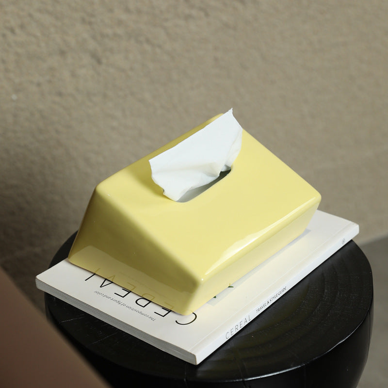 Glossy yellow geometric ceramic tissue box cover on book