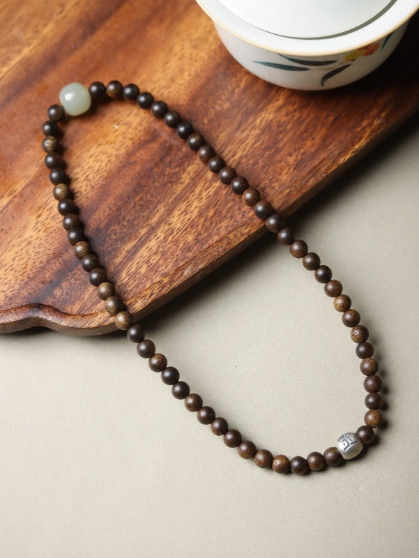 Natural agarwood 5mm bead strand with pale jade-tone focal bead and silver-tone accent