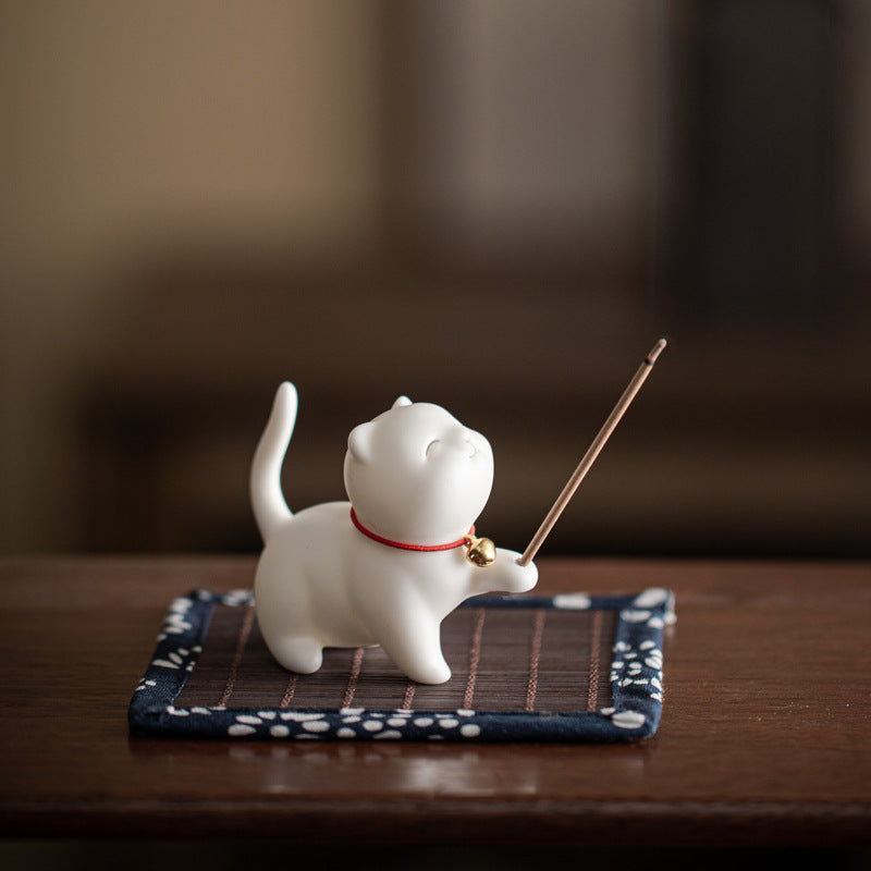 Ivory white Palace Cat ceramic incense holder on patterned bamboo mat
