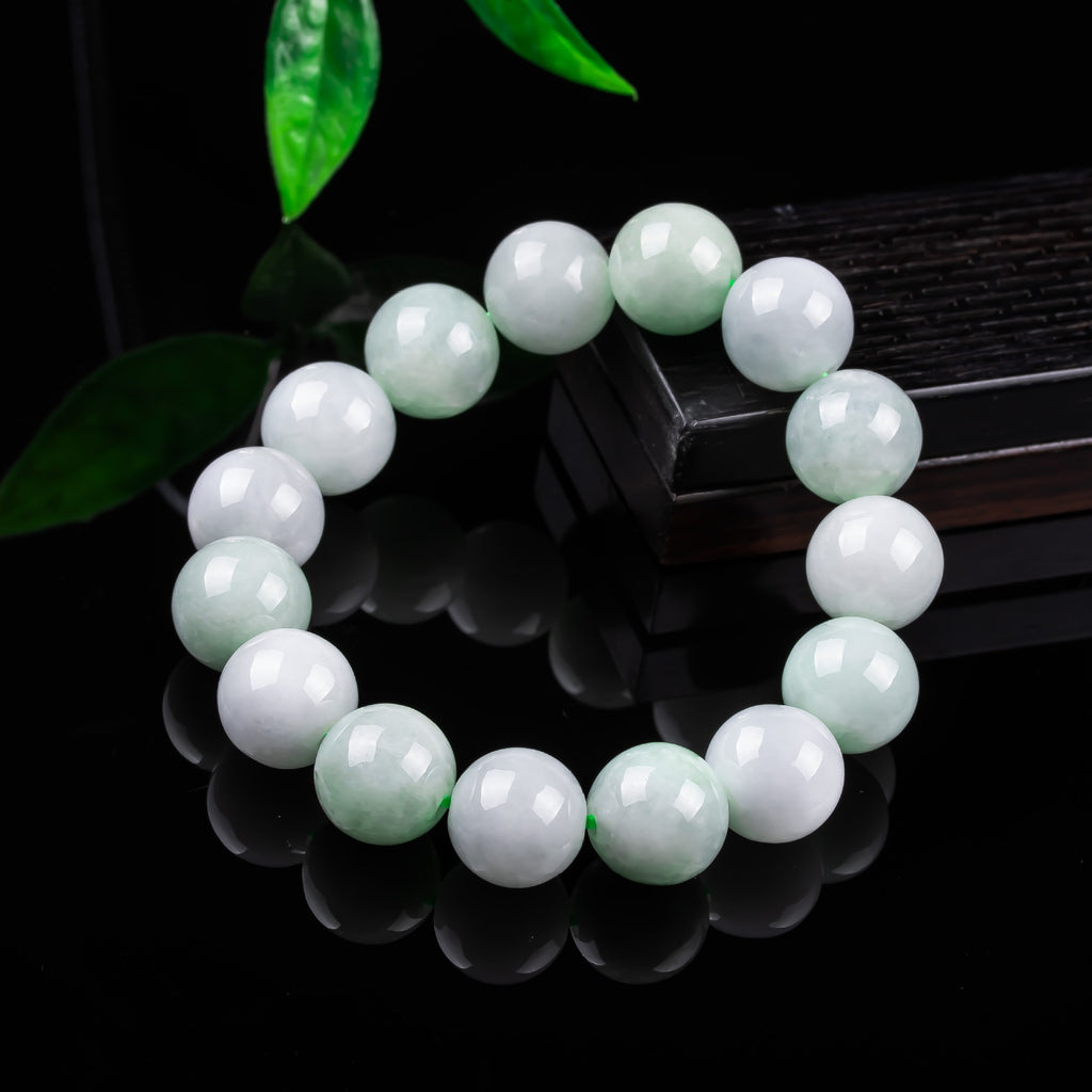 Pale green and white jadeite round beads showing natural translucency