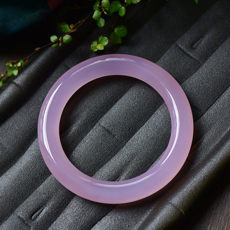 Thick round pink chalcedony bracelet shown on hand