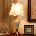 Porcelain table lamp with plum blossom and bird painting, brass-tone base and scalloped shade