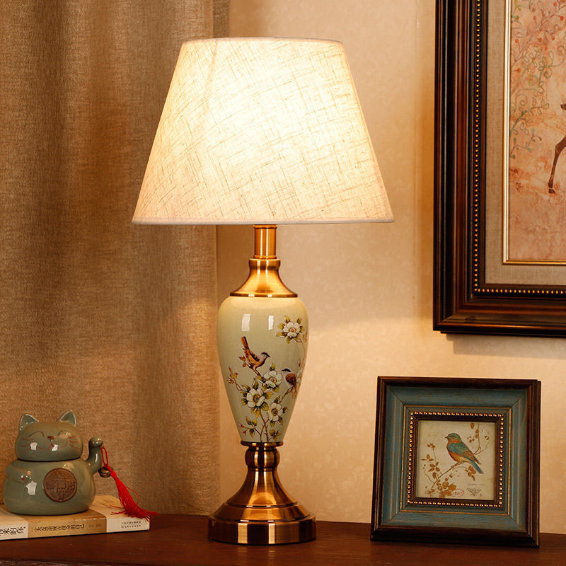 Plum blossom bird porcelain lamp with brass-tone base and warm shade