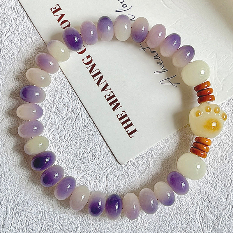 Purple floating-pattern Bodhi root single-wrap bracelet with pale yellow cat-paw focal bead and warm spacer accents