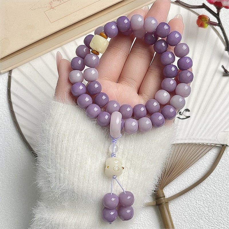 Purple Bodhi root double-wrap bracelet with pale carved focal charm and lilac dangling bead tassel