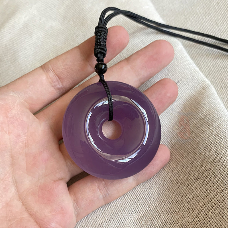 Purple chalcedony 50 mm peace buckle pendant held in hand