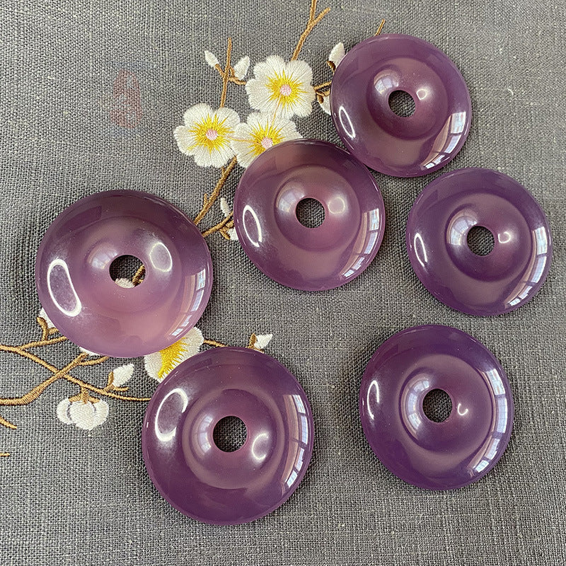 Natural purple chalcedony donut pendants showing tonal variation